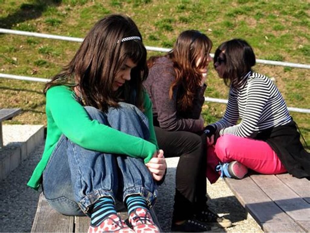Girl sitting away from a group of girls Effects of Being Single