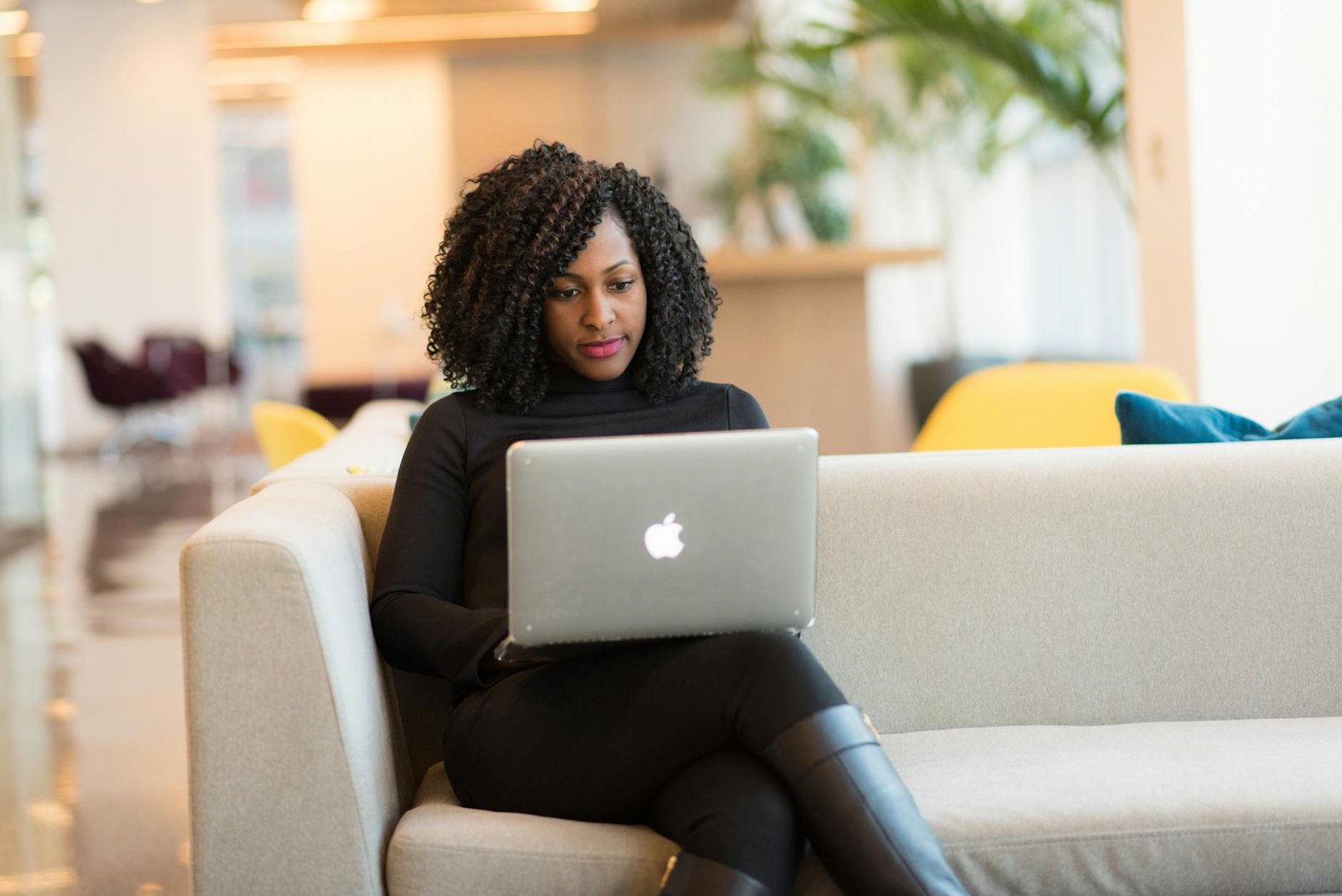 woman using macbook sitting on white couch How to Take Back Control at Work