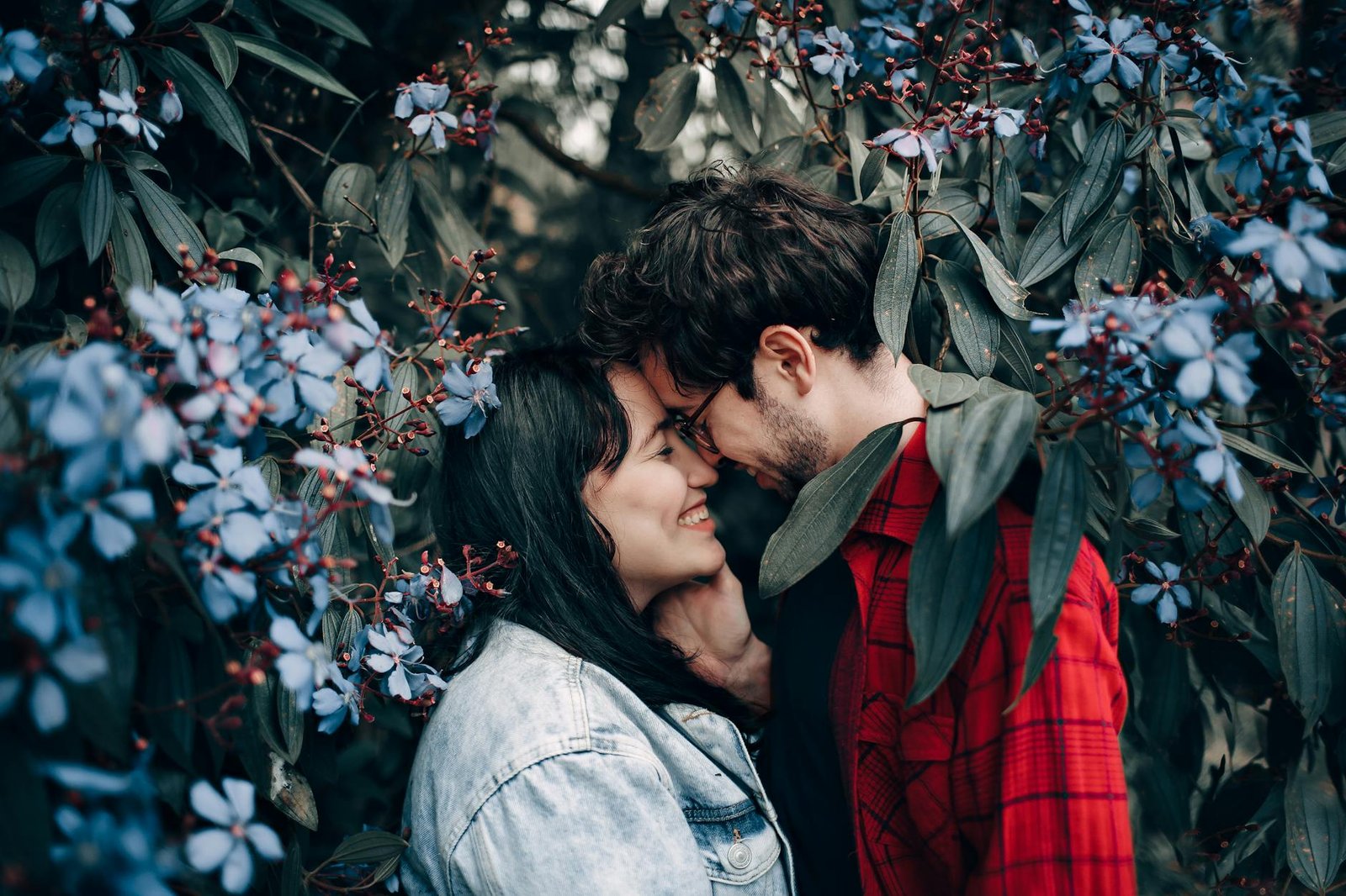 man and woman standing under flowering tree