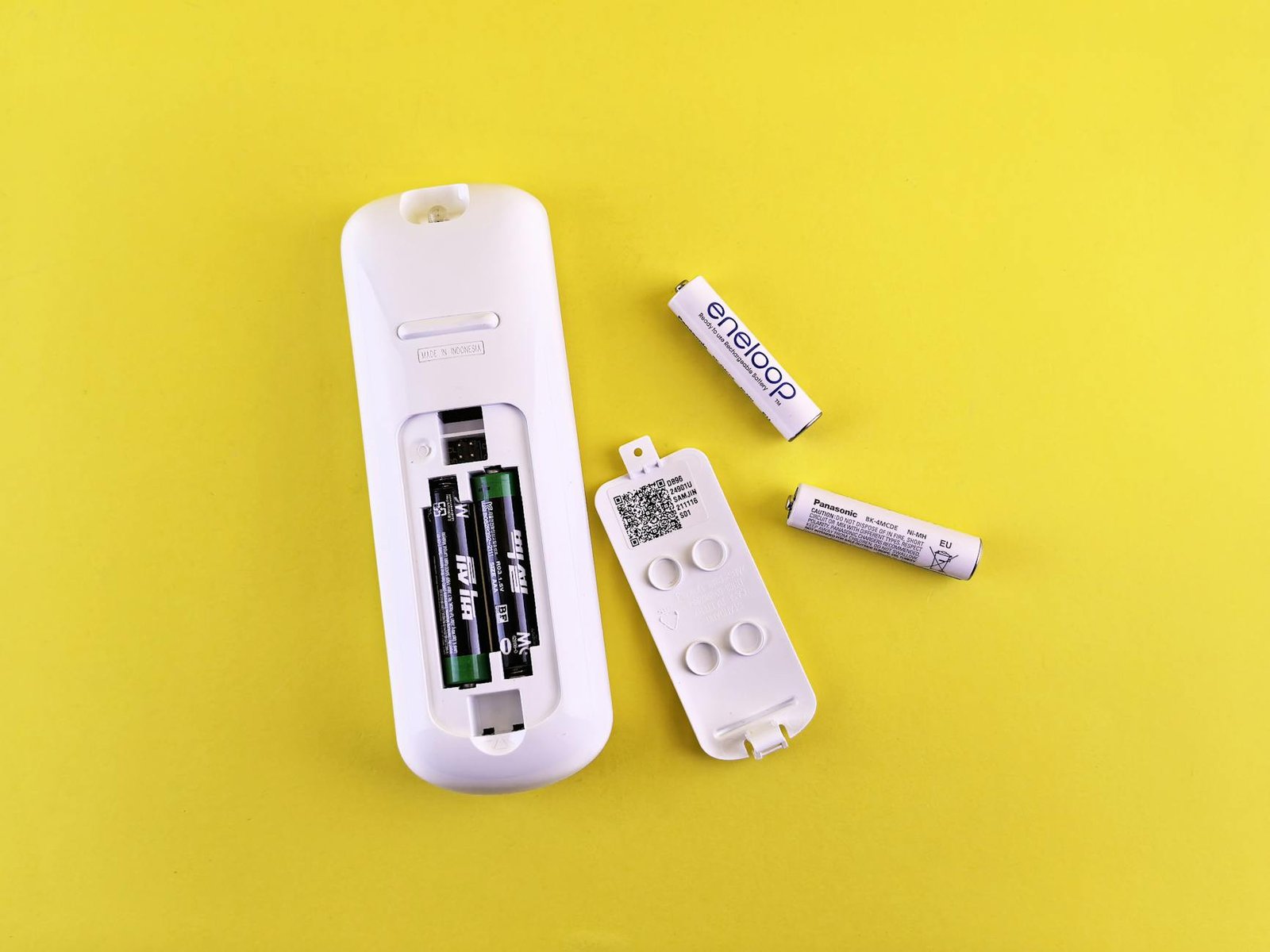 remote control with batteries on yellow background
