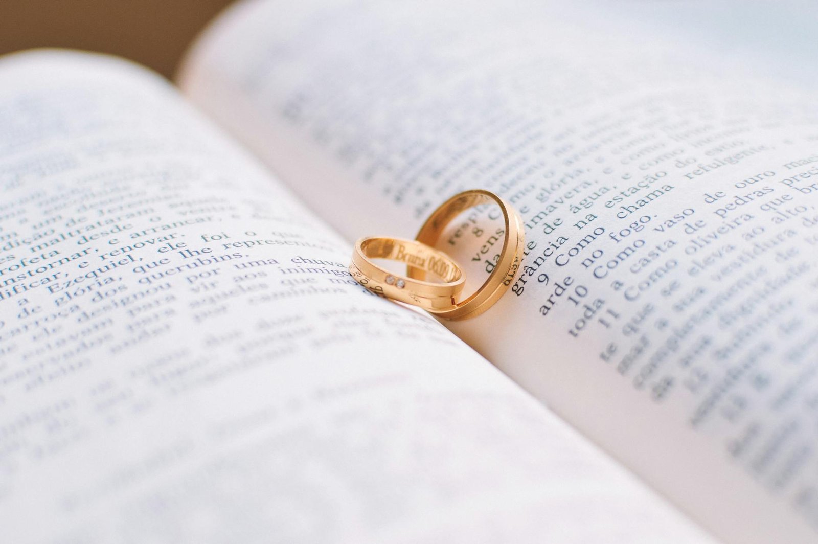 two gold colored wedding bands on book page Marriage