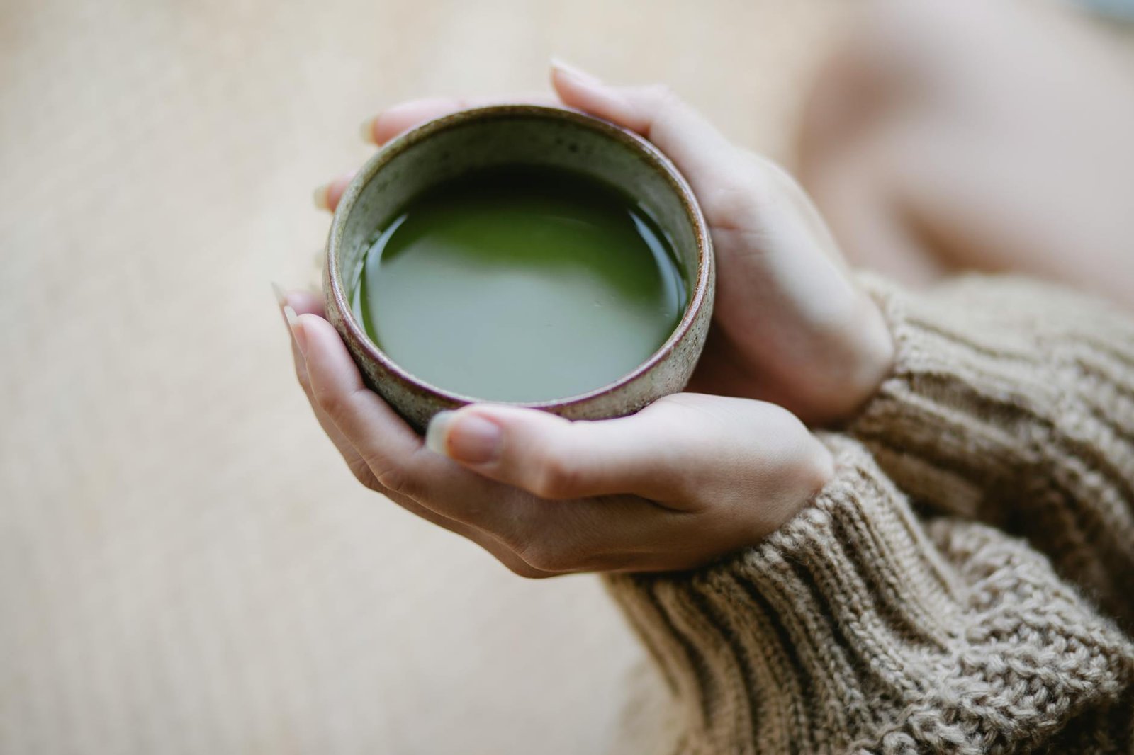 close up photo of woman holding matcha drink