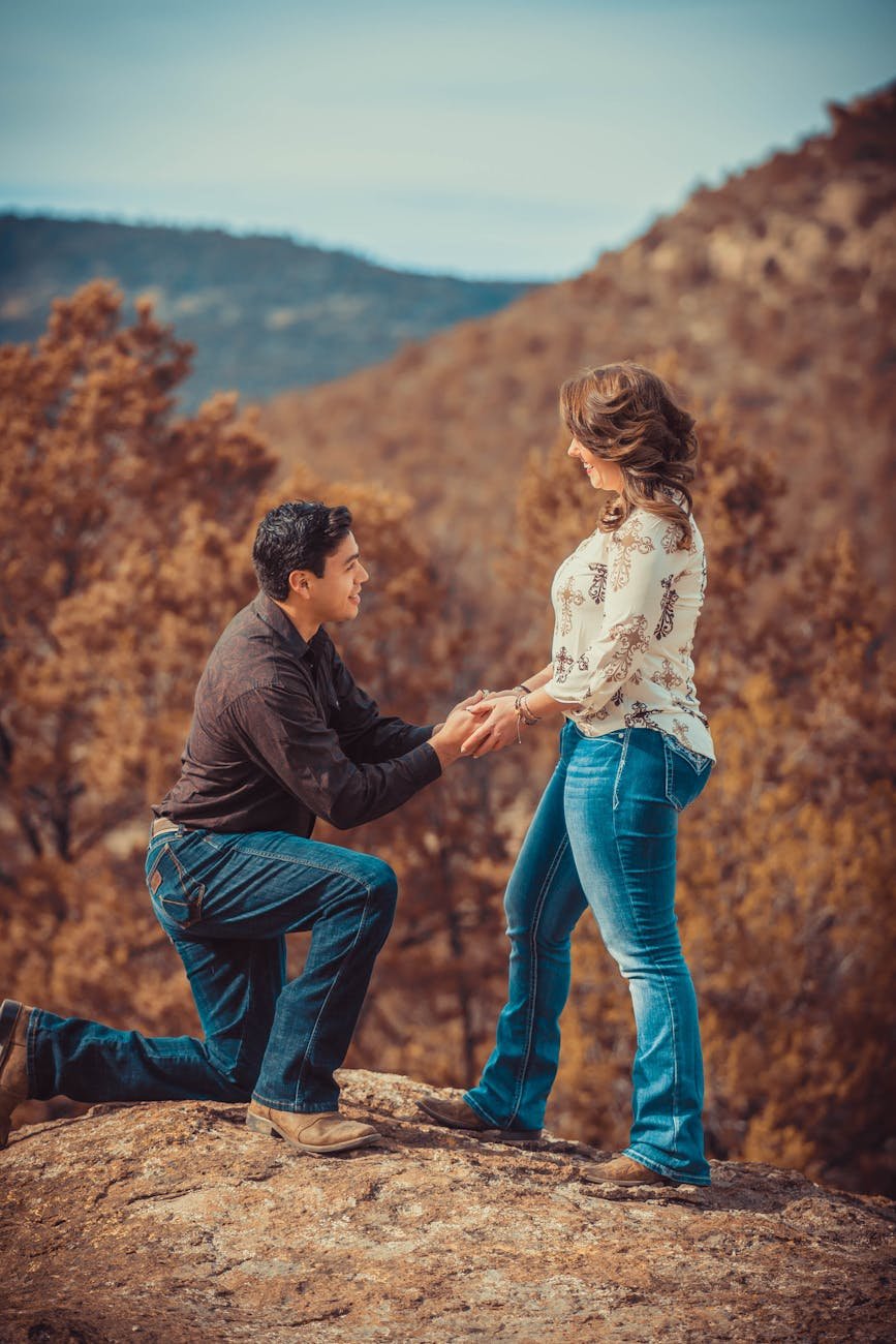 a man kneeling while proposing to her partner