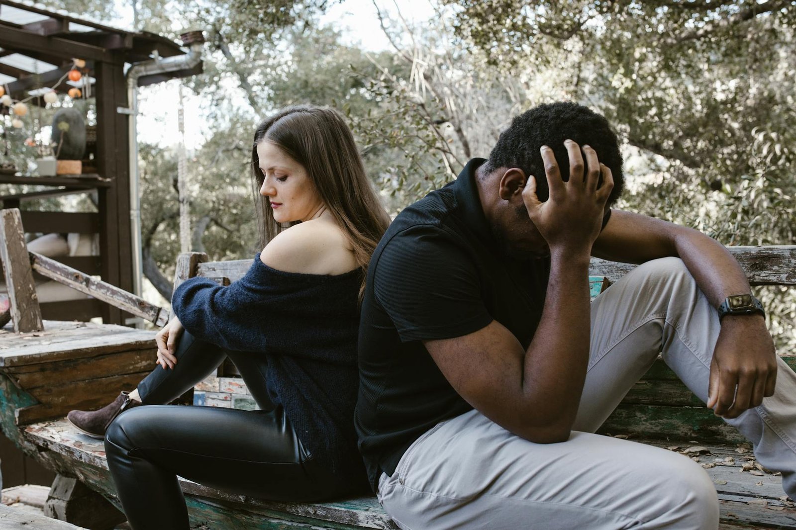 lonely couple sitting back to back