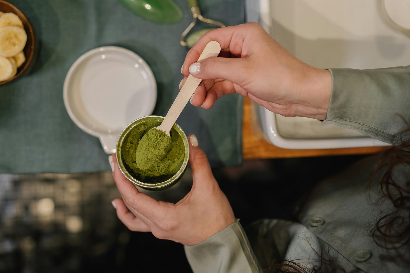 a person getting a spoon of matcha powder