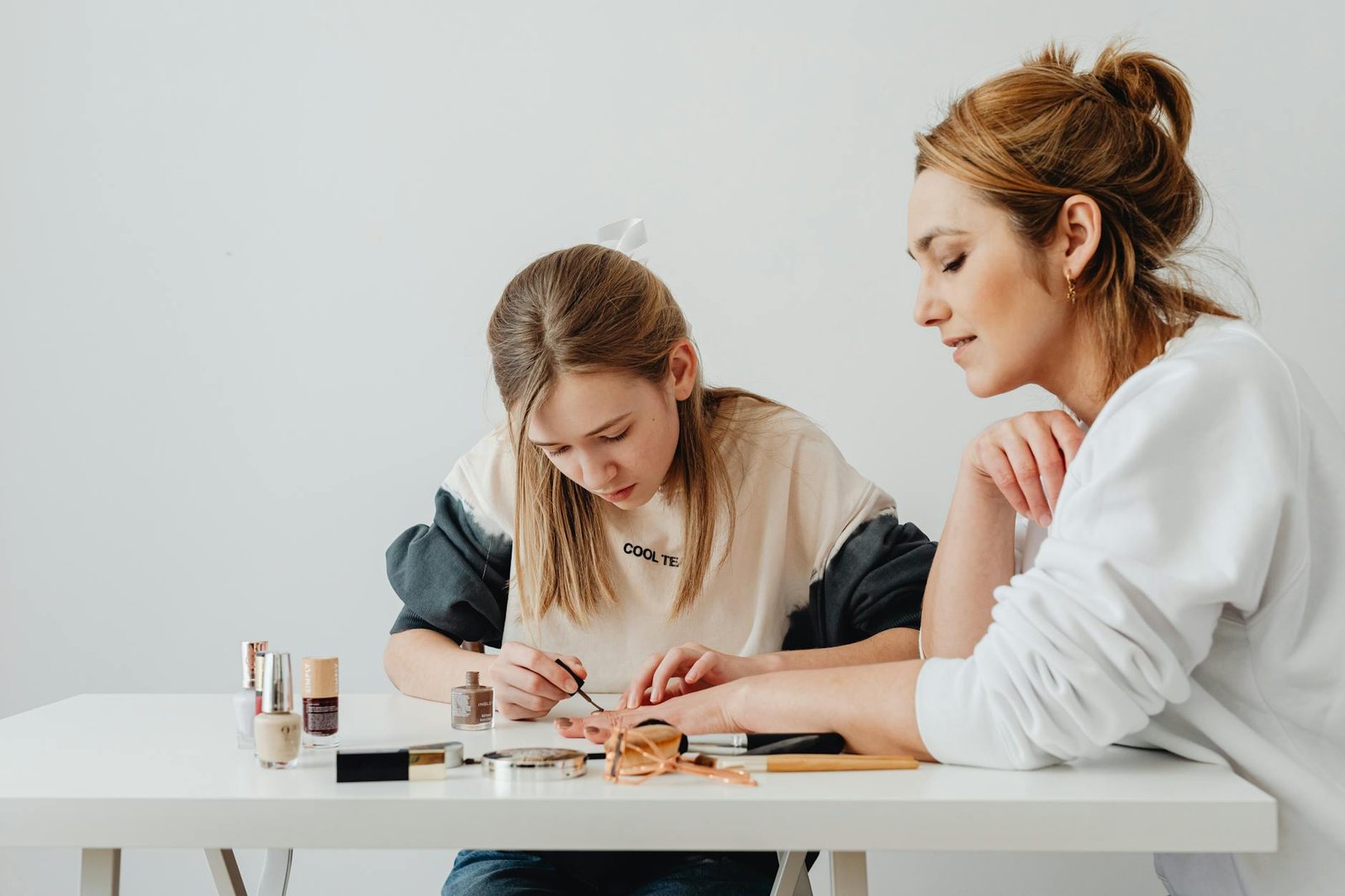 a woman putting makeup on another woman