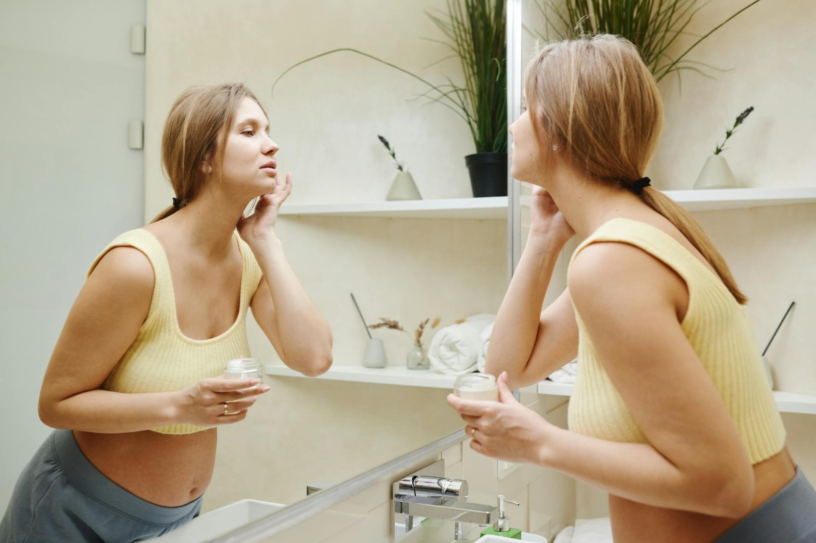 photo of a pregnant woman looking at a mirror