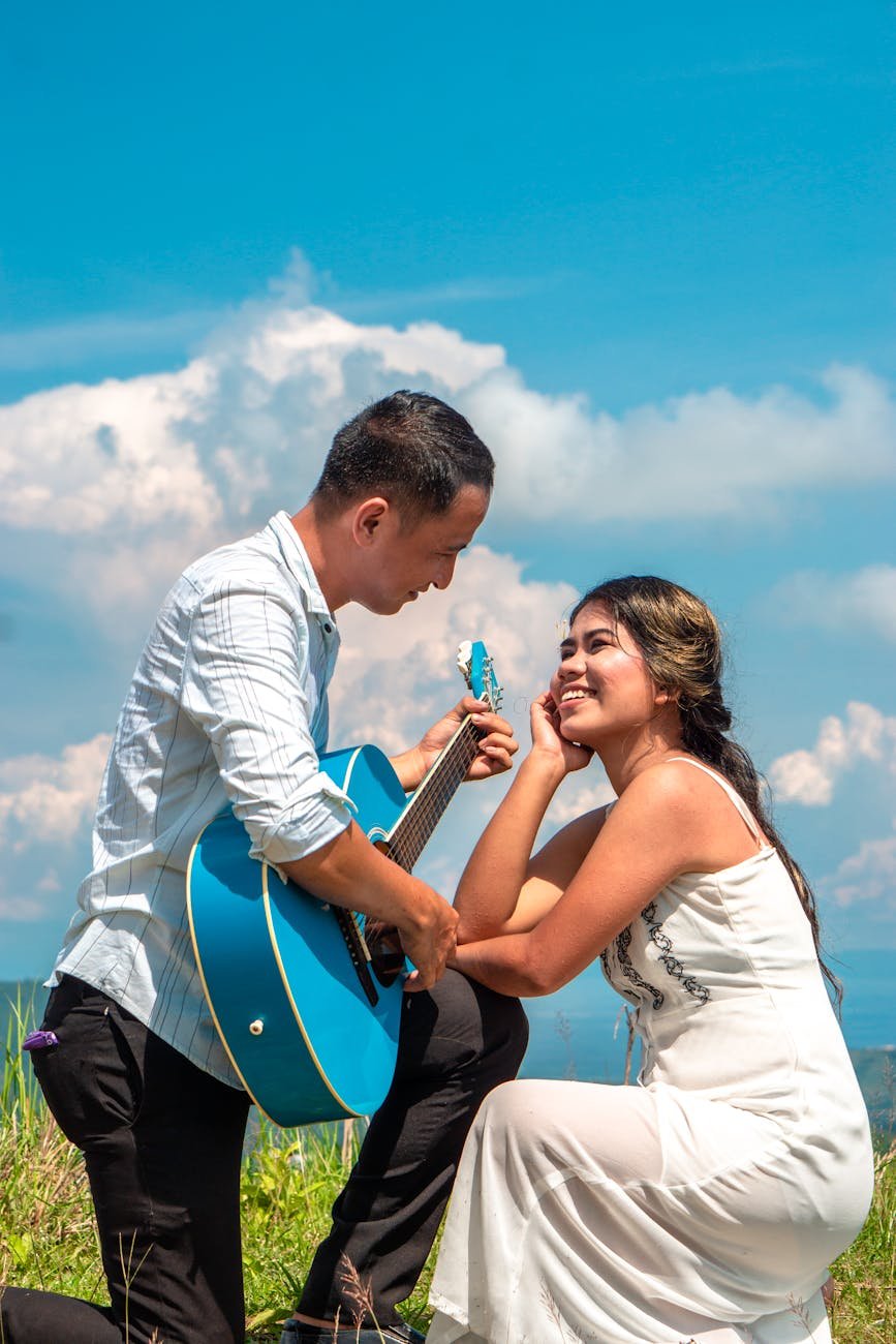 man playing guitar to a woman